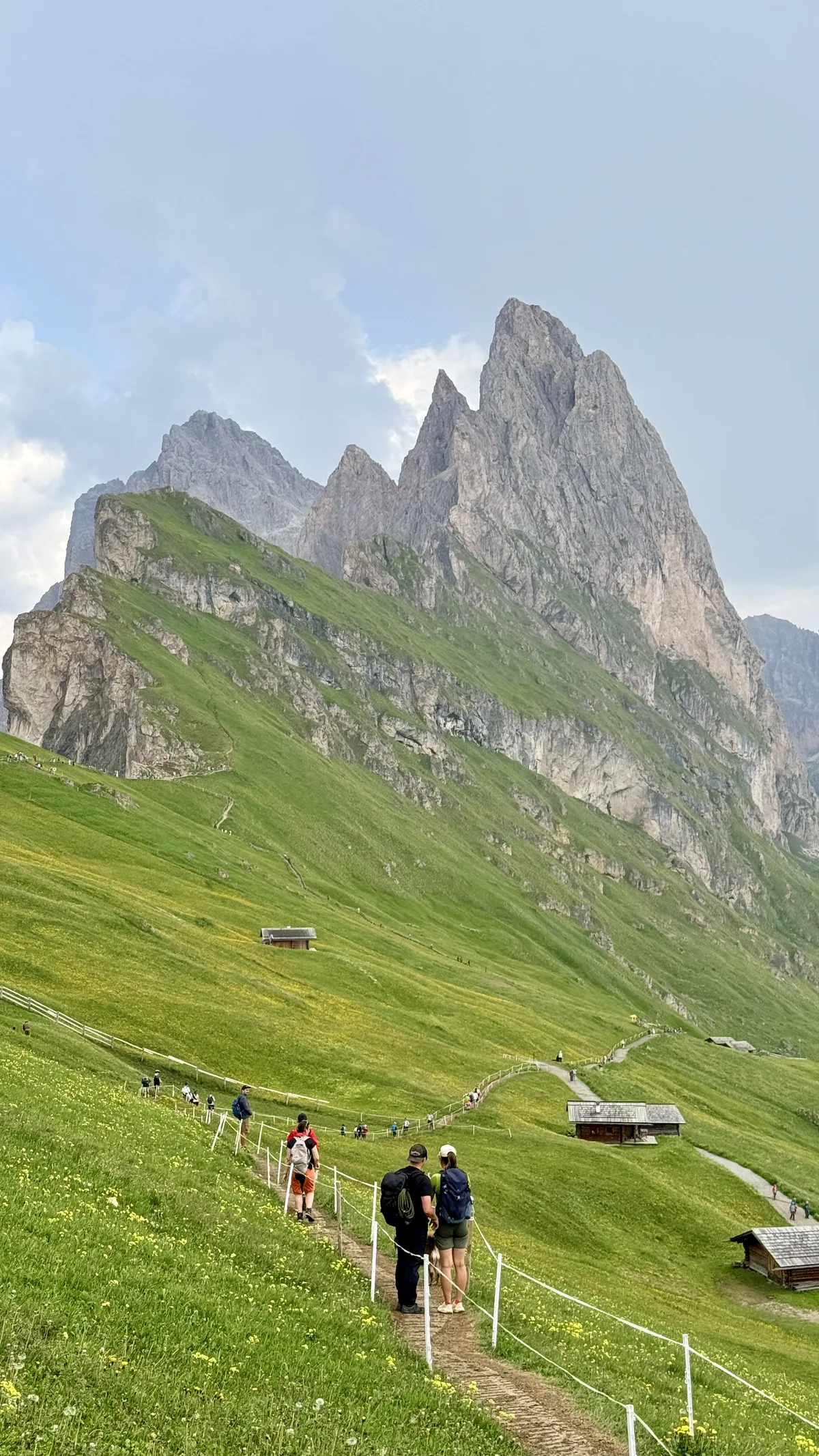 Hiking trail between rocky peaks and a green valley at Seceda, in the Dolomites