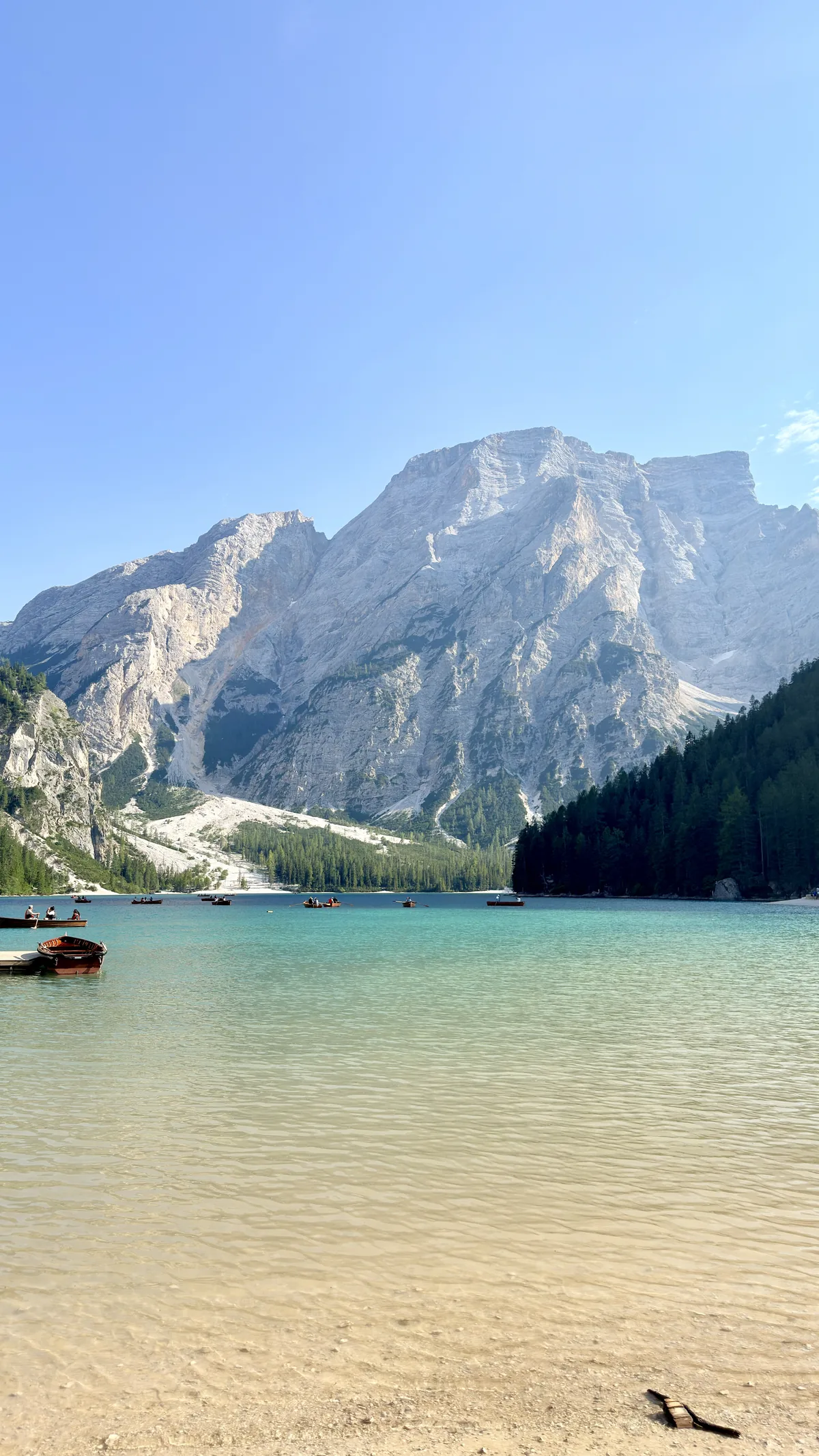 Lago di Braies with wooden boats and the Seekofel mountain in the background, in the Dolomites