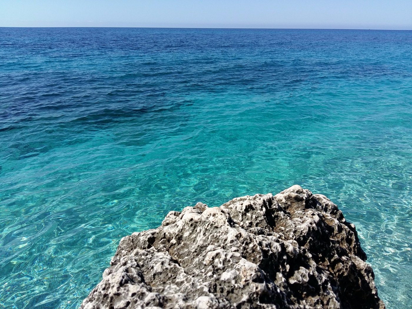 View of Dhërmi beach with blue sea and mountains in the background on the Albanian Riviera