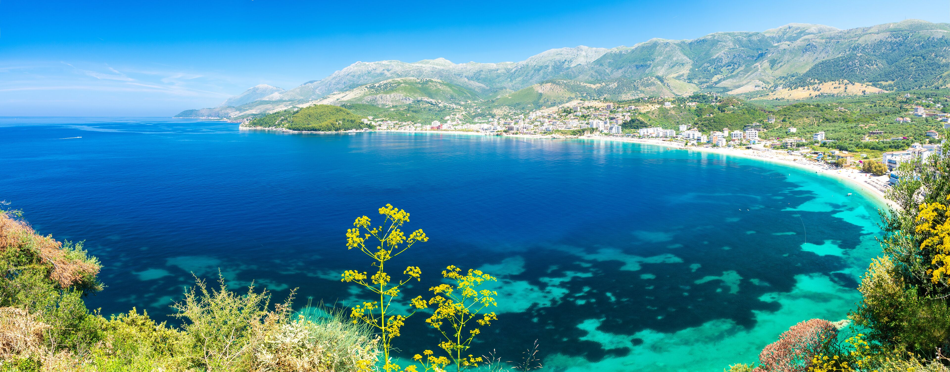 Himarë beach with calm sea and mountains in the background, Albania