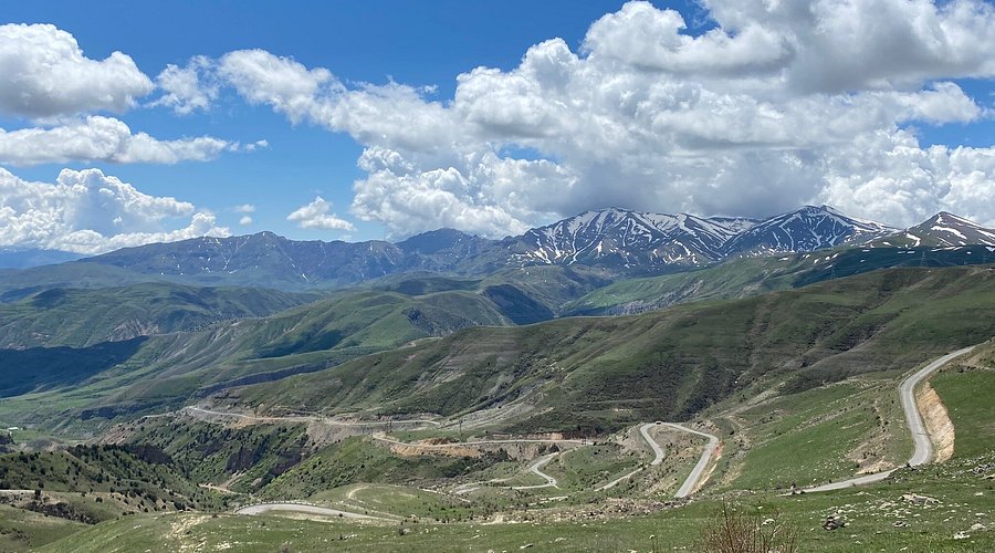 Winding road of Vardenyats Pass with snowy mountains in the background and an open landscape, Armenia