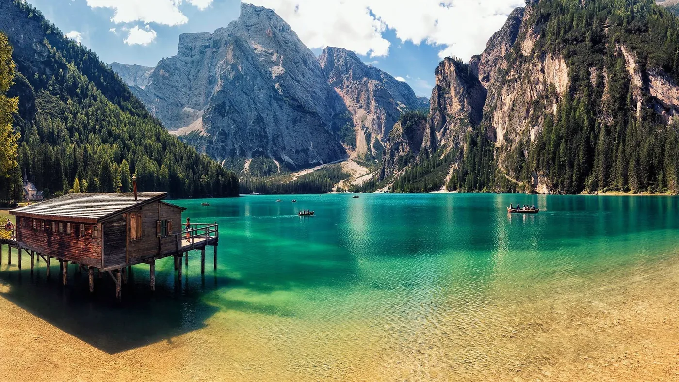 Lago di Braies with wooden boats and mountains in the background, in the Dolomites