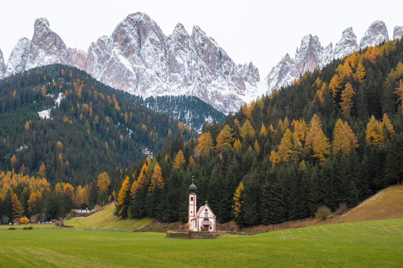Pequena igreja San Giovanni in Ranui cercada por floresta e montanhas nas Dolomitas