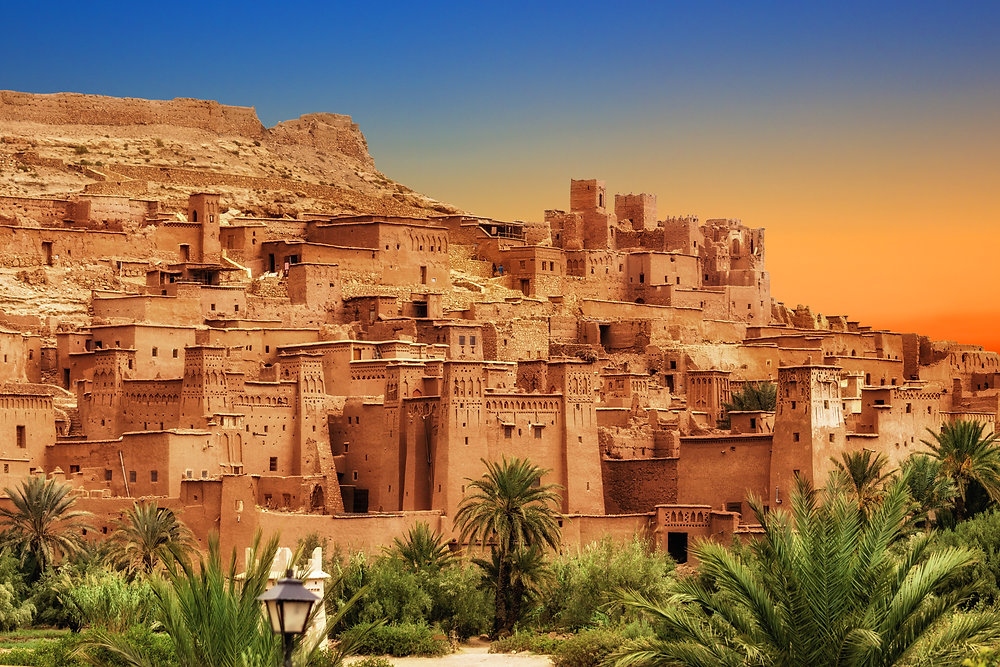 Vila fortificada de barro de Ait Ben Haddou ao entardecer com o rio e a planície ao redor, Marrocos