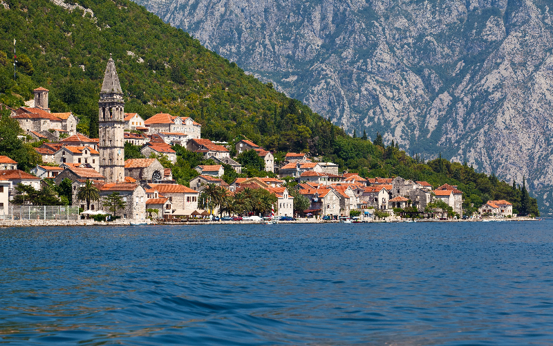 Vista panorâmica de Perast à beira da Baía de Kotor com casas de pedra e montanhas ao fundo, Montenegro