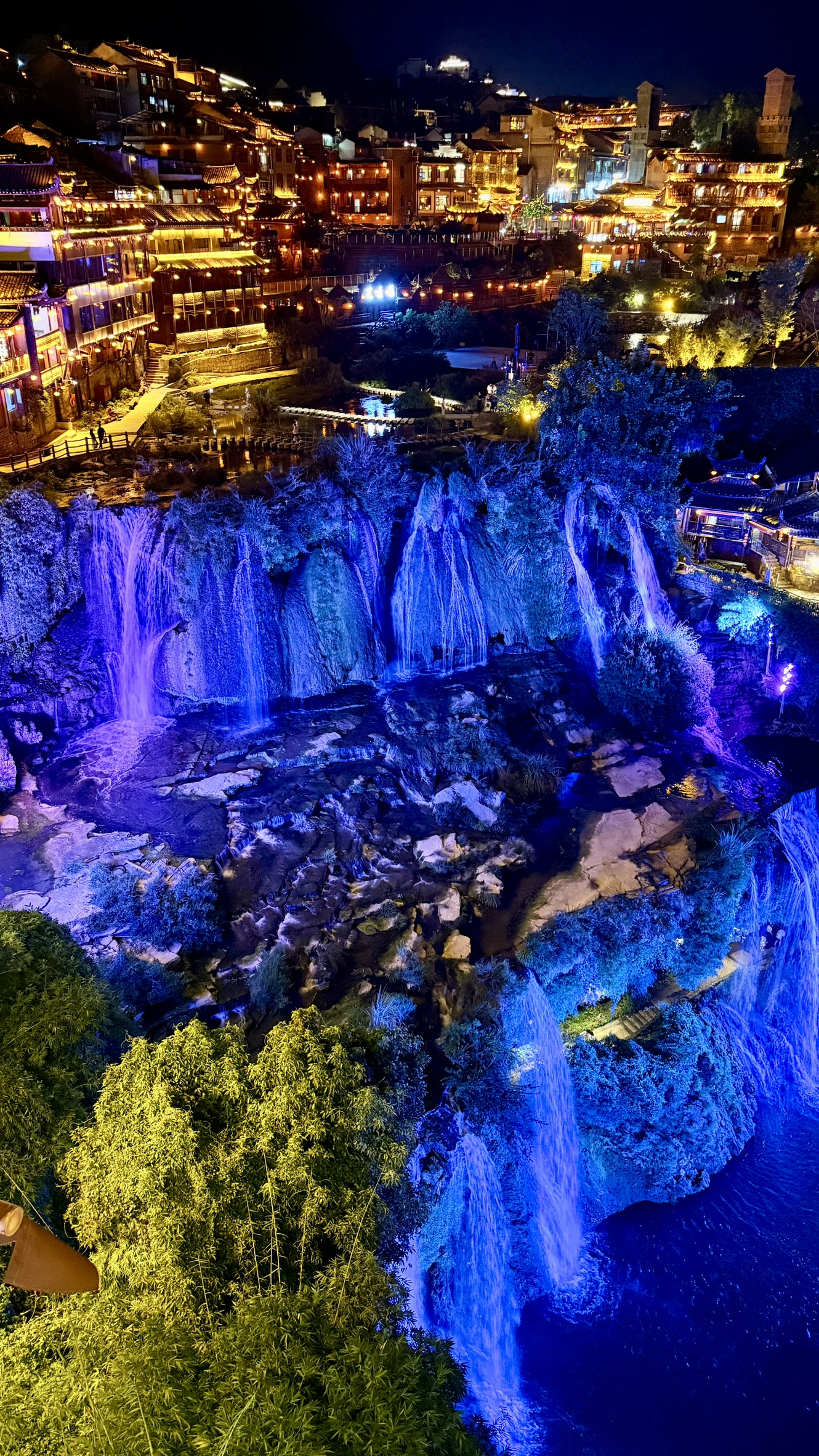 Cachoeira de Furong Ancient Town iluminada em azul à noite vista de cima
