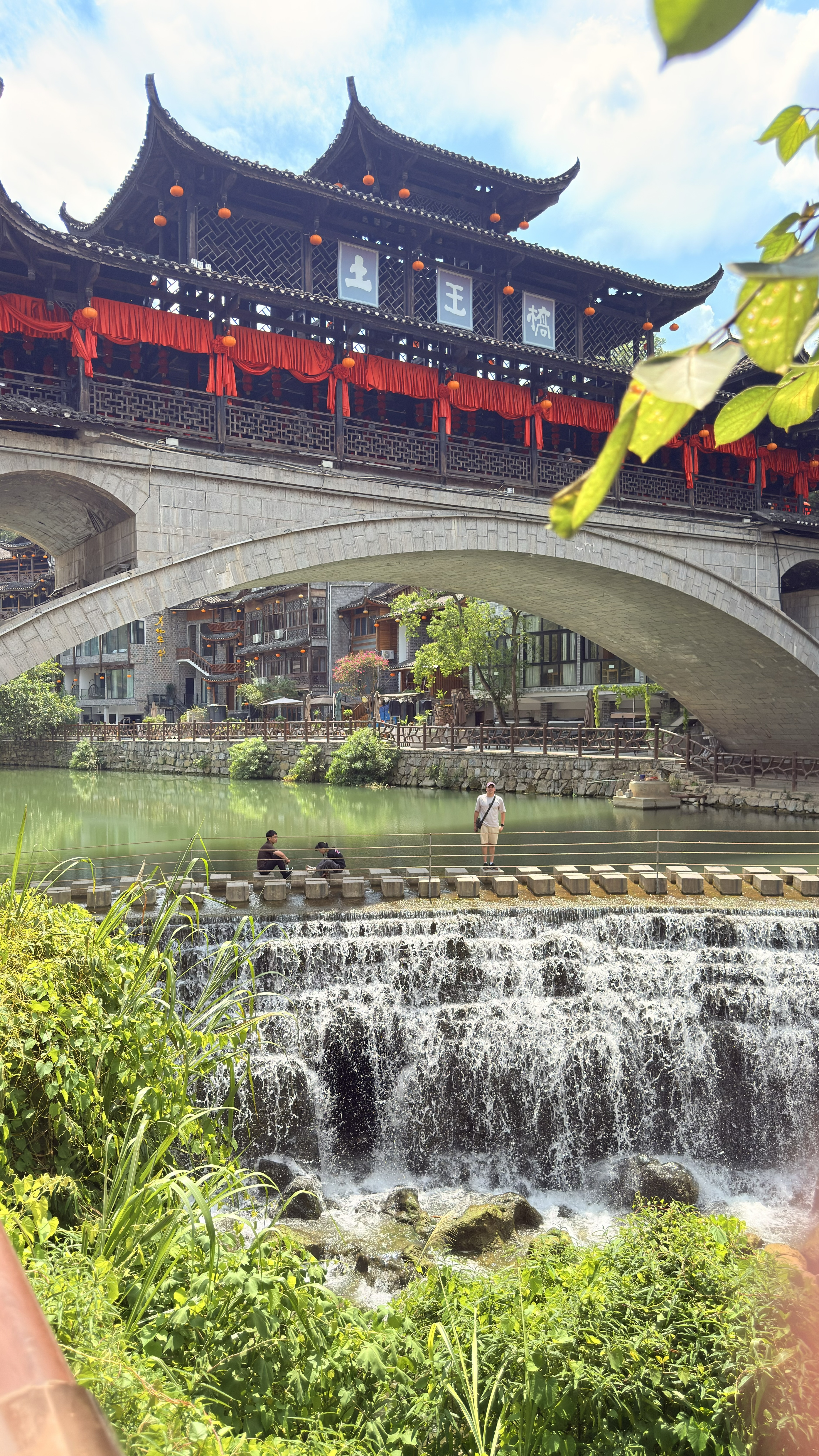 Tuwang Bridge em Furong Ancient Town — ponte histórica com pavilhão tradicional e cachoeira em Hunan