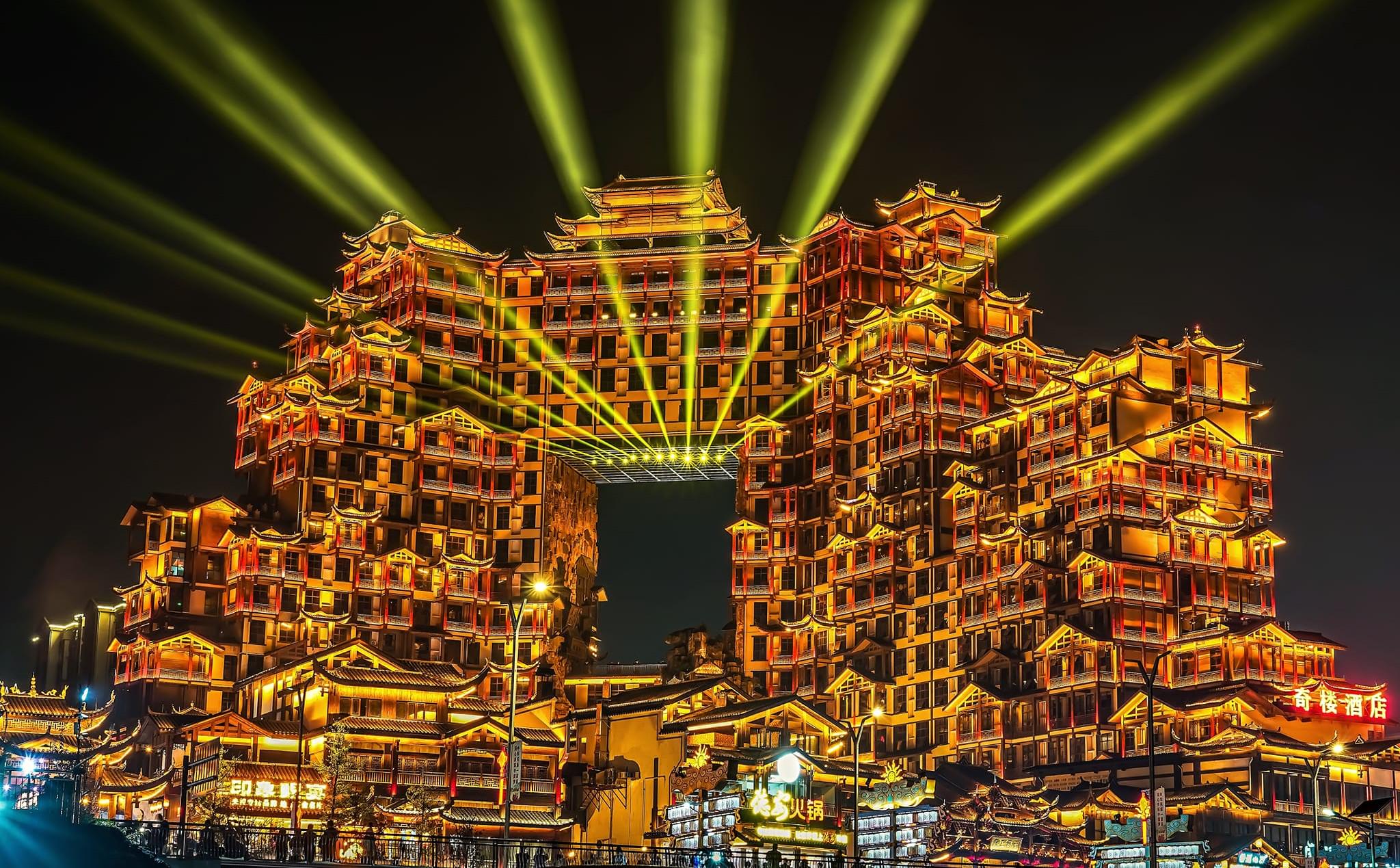 Vista de baixo do complexo 72 Qilou com arquitetura Tujia iluminada em Zhangjiajie