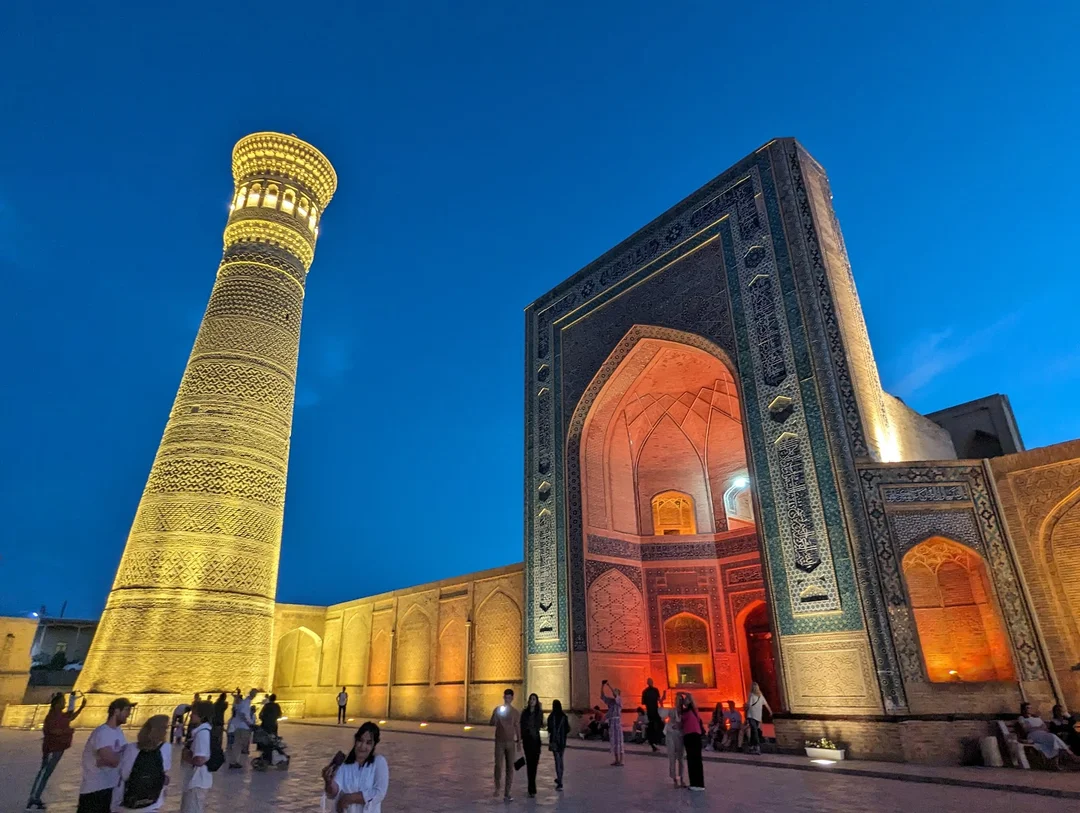 Complexo Poi-Kalyan com o minarete Kalyan iluminado à noite em Bukhara, Uzbequistão